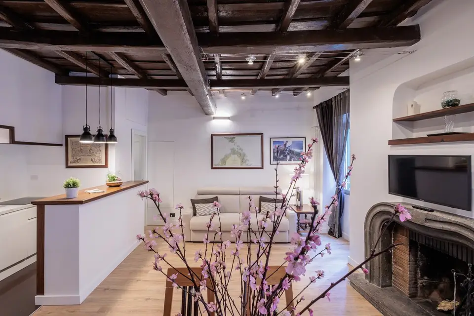 The living-room fireplace, with peach blossom on the table.