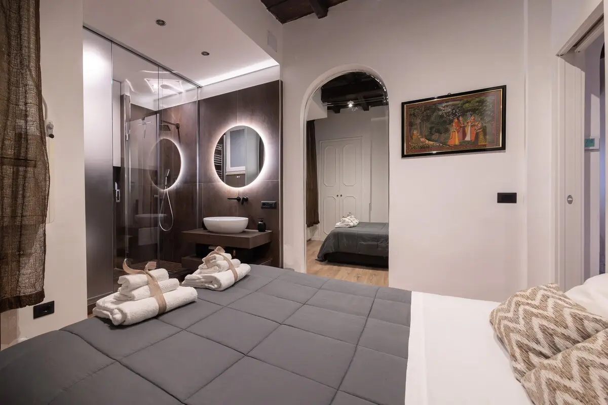 A bedroom with the bathroom behind a glass wall.